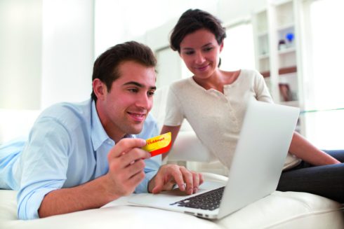 Couple using credit card to shop on line. Laptop.indoor on sofa; Shutterstock ID 151413998
